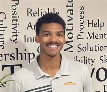 SERVPRO employee in front of motivational background