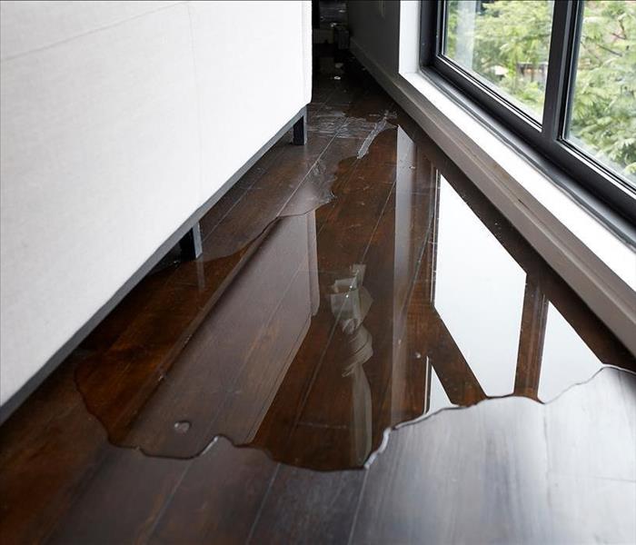 Water leaking and flooded on wood parquet floor. Room floor will damage after the water flooded